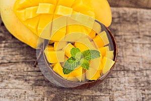 Mango fruit and mango cubes on the wooden table