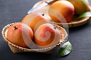 Mango fruit (Tommy Atkins) in basket on black background