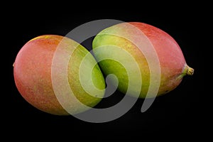 Mango of green and red color on a black background closeup