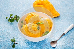 Mango ice cream, sorbet in a plate on a concrete background, top view