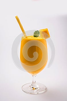 Mango Lassi or smoothie in big glass with mint leaf. Side angle Isolated over colourful background