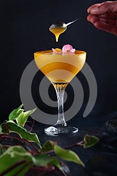 Mango Margarita in a glass on a black background. Alcoholic cocktail based on mango pulp. The cocktail is decorated with