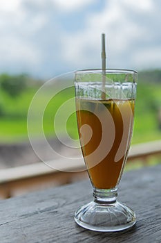 Mango papaya banana iced drink with rice fields in the background