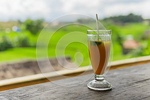 Mango papaya banana iced drink with rice fields in the background