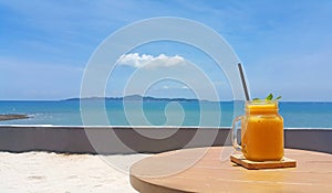 Mango shake with bright sky and sea background photo