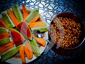 Mango slices, Watermelon slices, Cucumber slices on a dish. Along with the Sprout salad. Prepared for heavy diet.