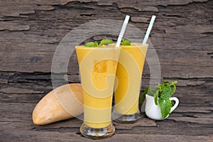 Mango smoothies juice and fruit mango from the wood background