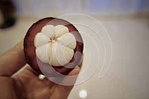 Mangosteen and cross section showing the thick purple skin and white flesh of the queen of fruits