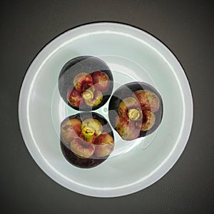 Mangosteen fruit ornament on a white plate