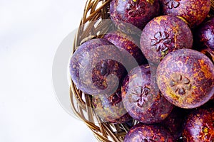 Mangosteen in traditional basket and bananas are captured in top angle