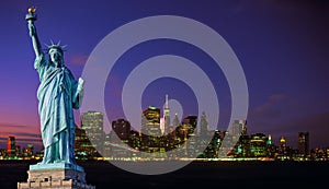 Manhattan skyline at night and Statue of Liberty.