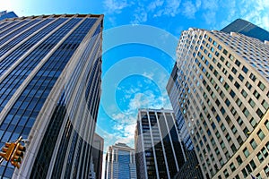 Manhattan skyscrapers, bottom-up view on blue sky background, USA