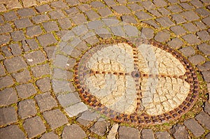 Manhole on a cobblestone in the street during daytime