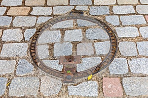 Manhole cover on a cobblestone street in Limoges