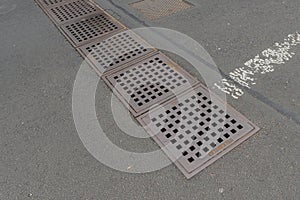 Manhole drainage grates frame rusty metal steel cover grid grill in asphalt photo