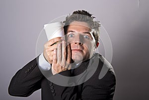 Maniac addict businessman holding take away coffee in caffeine addiction photo