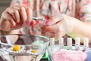 Manicure applying, cutting the cuticle with scissors