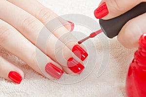 Manicure - Beautiful manicured woman`s nails with red nail polish on soft white towel.