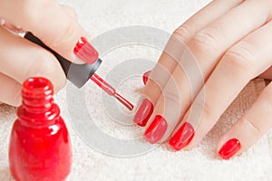 Manicure - Beautiful manicured woman`s nails with red nail polish on soft white towel.