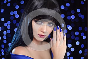 Manicure. Blue makeup. Beautiful brunette woman face close up po