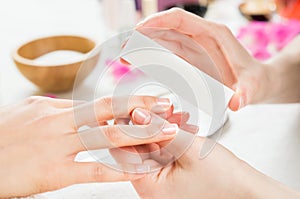 Manicure with buffer at nail salon photo