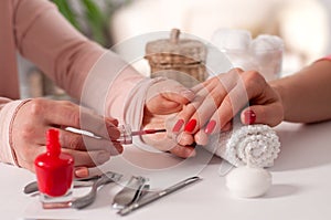 Manicure concept. Beautiful woman`s hand wiith red nails in the spa.