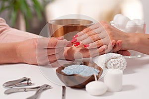 Manicure concept. Beautiful woman`s hand wiith red nails in the spa.