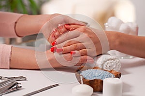 Manicure concept. Beautiful woman`s hand wiith red nails in the spa.