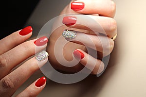 Manicure design is bright red and rhinestones