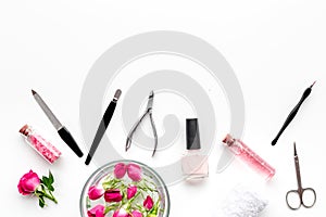 Manicure equipment with nail polish and rose petals white background top view space for text