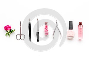 Manicure equipment with nail polish and rose petals white background top view space for text