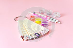 Manicure, gel nail art design equipment, tools and samples on pink background