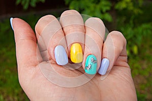 Manicure - gel polish color in bright summer tones, butterflies are pasted on one nail - photo