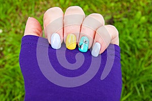 Manicure - gel polish color in bright summer tones, butterflies are pasted on one nail - photo