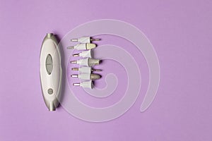 Manicure machine with nozzles on purple background with copy space