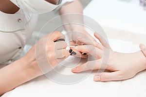 Manicure. Master applies varnish drawing on nails gel in spa . Closeup finger nail care by specialist in beauty salon.