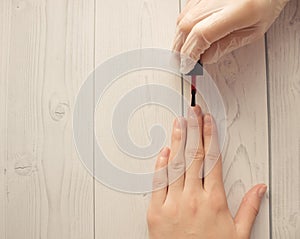 Manicure master paints the nails of the client. Manicurist with a brush paint your nails in red. photo