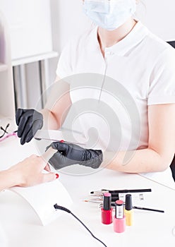 The manicure master shapes the nails with a nailfile photo