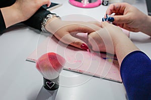 Manicure nail paint, Closeup shot of a woman in a nail salon receiving a manicure by a beautician