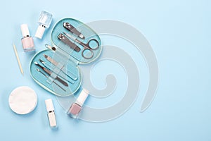 Manicure or pedicure equipment, spa set with nail coat or polish, on blue background, horizontal, copy space, top view