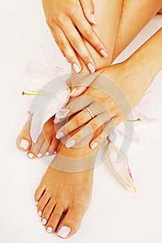 Manicure pedicure with flower lily close up on white perfect shape hands spa salon