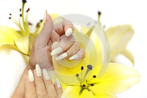 Manicure and pedicure at a long oval shaped nails with yellow lilies