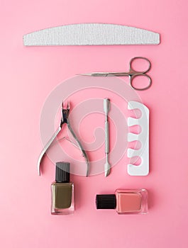Manicure and pedicure nail care tools set on pink background knolling flat lay. Sponge separator, cuticle pusher, nail file