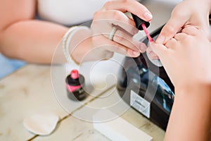 Manicure procedure with the pink nail polish