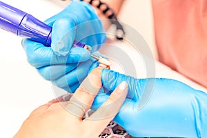 Manicure process. The manicure master polishes the nail using a machine. Close up manicure process