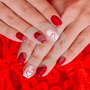 Manicure, red gel polish and hearts on nails