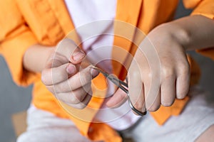 Manicure scissors in the hands of a child cut nails. Boy cutting his nails