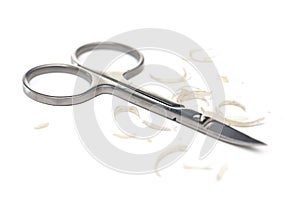 Manicure scissors and nail clipping on white background