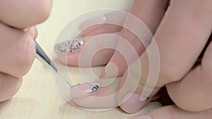 Manicure spacialist drawing lace on female nails.