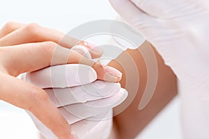 Manicure specialists hands applying glue for nail